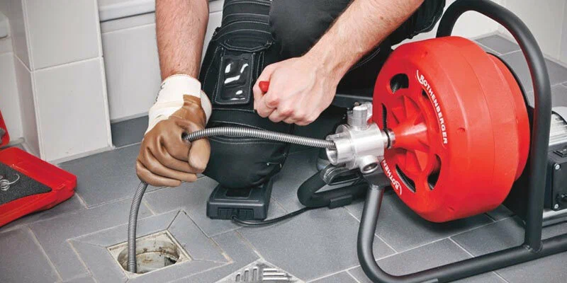Plumber using a drain-cleaning machine in Winter Haven