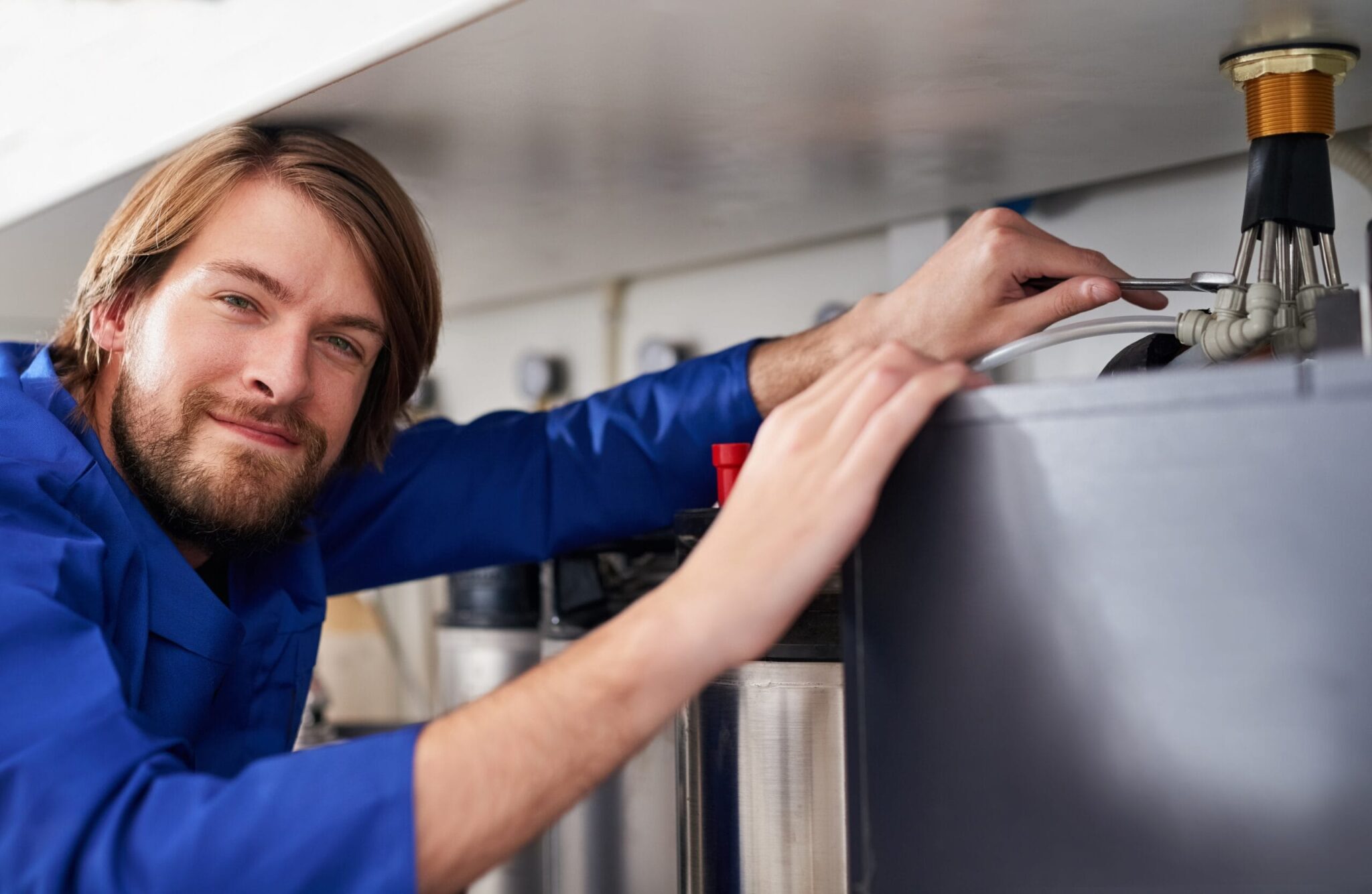 Technician servicing a residential water heater tank in Winter Haven