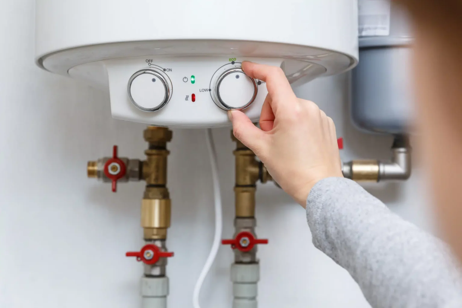 Homeowner adjusting the temperature controls on a water heater in Winter Haven